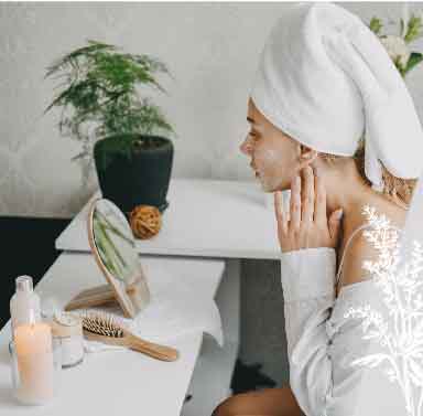 Femme se faisant un masque de beauté devant son miroir